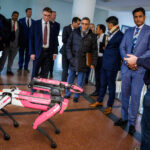 Prof. Frank Fitzek (rechts), Sprecher des Exzellenzclusters Centre for Tactile Internet with Human-in-the-Loop (CeTI), erläutert, wie  der Roboterhund „Spot“ von Boston Dynamics eingesetzt wird. 
Besuch der Delegation des indischen Botschafters in Deutschland mit dem Industrieminister des südindischen Bundesstaates Tamil Nadu an der Technischen Universität Dresden, fotografiert am 02. Dezember 2024. 
Foto: André Wirsig für die TU Dresden